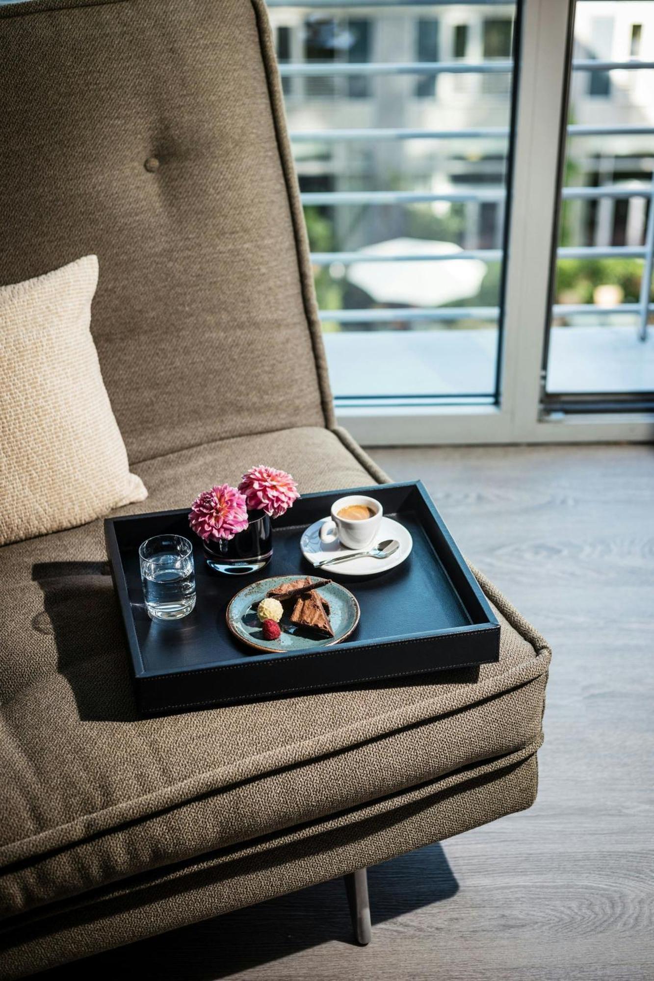 فندق لو ميريديان ميونيخ المظهر الخارجي الصورة A tray with a cup of coffee and a dessert